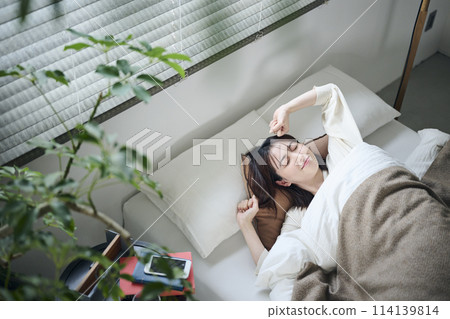 20多歲的女性早上起床伸展身體 20多歲的女性早上起床伸展身體 114139814