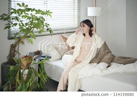 20多歲女子躺在床上喝水 114139880
