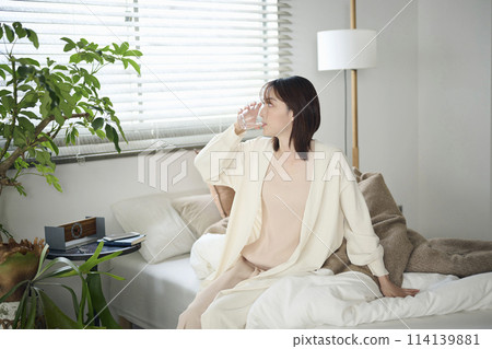 20多歲女子躺在床上喝水 114139881