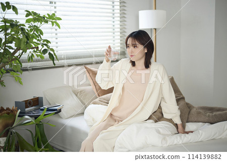 20多歲女子躺在床上喝水 114139882