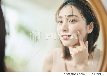 20 多歲的女人觸摸她的皮膚,倒影,鏡子 20 多歲的女人觸摸她的皮膚,倒影,鏡子 114139912