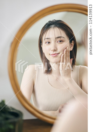 Woman in her 20s touching her own skin, reflection, mirror Woman in her 20s touching her own skin, reflection, mirror 114139913