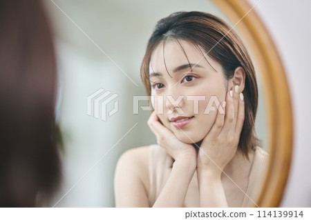 20 多歲的女人觸摸她的皮膚,倒影,鏡子 20 多歲的女人觸摸她的皮膚,倒影,鏡子 114139914