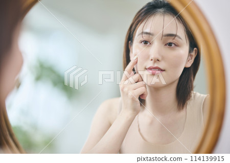 Woman in her 20s touching her own skin, reflection, mirror Woman in her 20s touching her own skin, reflection, mirror 114139915