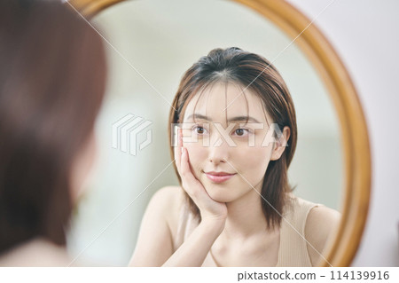 Woman in her 20s touching her own skin, reflection, mirror Woman in her 20s touching her own skin, reflection, mirror 114139916