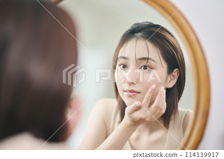 Woman in her 20s touching her own skin, reflection, mirror Woman in her 20s touching her own skin, reflection, mirror 114139917