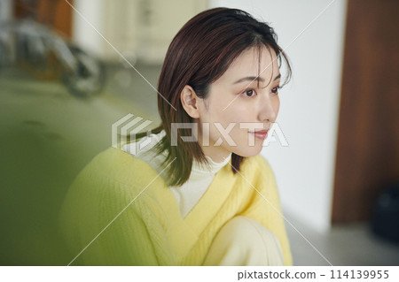 一名20多歲的女性試圖在床上穿上襪子 114139955