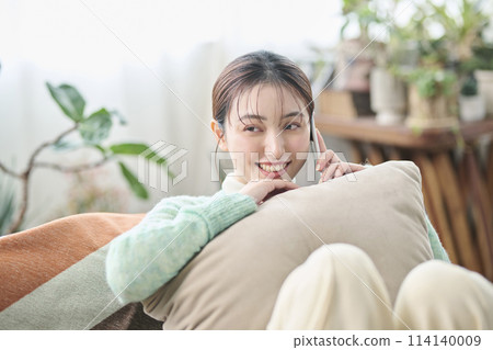 A woman talking on the phone with a friend in the living room 114140009
