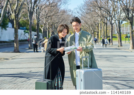 Man and woman lost with suitcases Man and woman lost with suitcases 114140189
