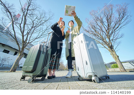 Man and woman lost with suitcases Man and woman lost with suitcases 114140199