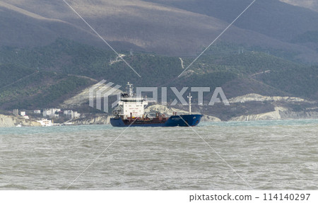 Sea freighter sailing in the middle of the ocean with big waves. Sea freighter sailing in the middle of the ocean with big waves. 114140297