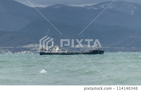 Sea freighter sailing in the middle of the ocean with big waves. Sea freighter sailing in the middle of the ocean with big waves. 114140348
