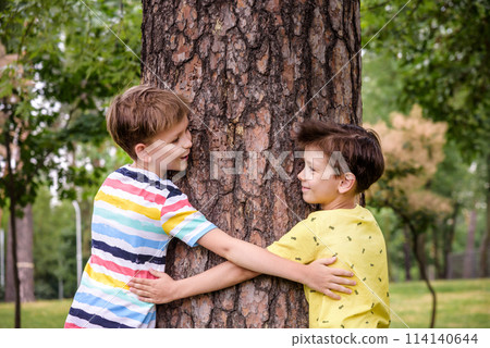Little boy hugs a tree trunk - children love the nature, sustainability concept. Save the nature Little boy hugs a tree trunk - children love the nature, sustainability concept. Save the nature 114140644