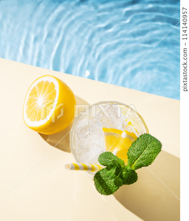 Cold lemonade in a glass with lemon, mint and ice on a yellow background Cold lemonade in a glass with lemon, mint and ice on a yellow background 114140957