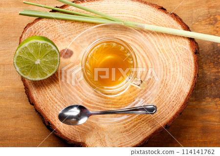 lemongrass tea in glass cup on rustic tree trunk table lemongrass tea in glass cup on rustic tree trunk table 114141762