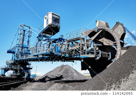 Bucket wheel stacker reclaimer in maritime bulk terminal of coal harbor. Bucket wheel stacker reclaimer in maritime bulk terminal of coal harbor. 114142095