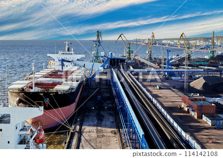 Coal harbor at maritime dry bulk terminal, bulk carrier under loading. 114142108