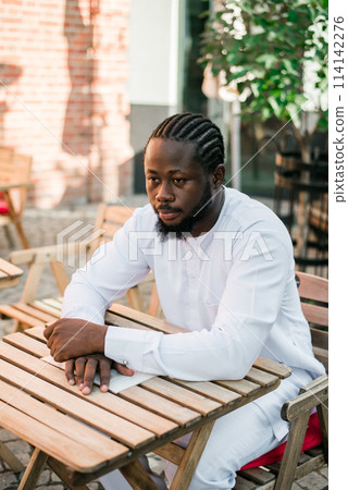 Cheerful male tourist portrait dress in white wear dashiki ethnic smiling at city street or small town background. African American travel model have free time. Millennial generation and gen z people Cheerful male tourist portrait dress in white wear dashiki ethnic smiling at city street or small town background. African American travel model have free time. Millennial generation and gen z people 114142276