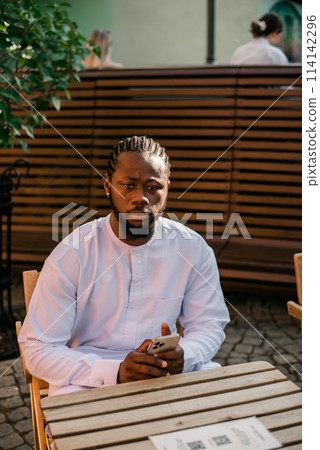 Cheerful male tourist portrait dress in white wear dashiki ethnic smiling at city street or small town background. African American travel model have free time. Millennial generation and gen z people Cheerful male tourist portrait dress in white wear dashiki ethnic smiling at city street or small town background. African American travel model have free time. Millennial generation and gen z people 114142296