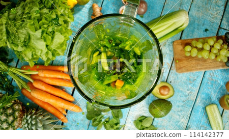 Freeze motion of mixing pieces of fruit and vegetables in blender, top shot 114142377