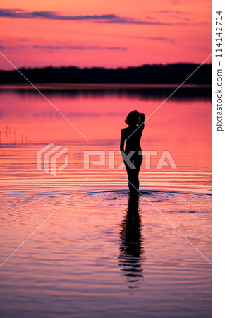 Women silhouette sunset on the lake Women silhouette sunset on the lake 114142714