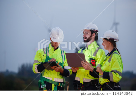 Team engineer wearing safety uniform holding laptop discussed plan about renewable energy Team engineer wearing safety uniform holding laptop discussed plan about renewable energy 114143842