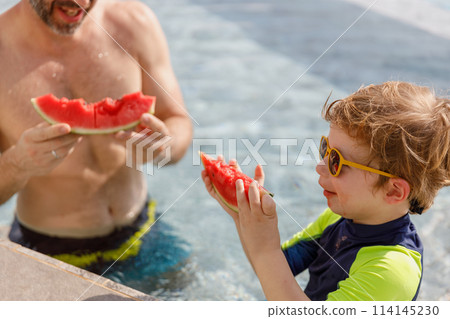 Happy vacation kid boy and father eat watermelon have fun enjoy at swimming pool. 114145230