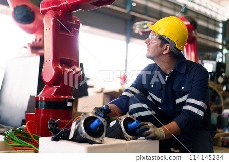 Professional caucasian white ethnicity male technician operating the heavy duty machine in the lathing factory. Technician in safety and helmet suit controlling a machine in factory. 114145284