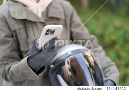 拿著智慧型手機的女性騎士的手 拿著智慧型手機的女性騎士的手 114145612