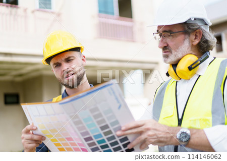 Engineers or construction contractors discussing together at the empty land about construction plan. Man talking to real estate contractor on building blueprint. 114146062