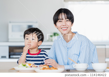 Mother and toddler having breakfast. 114146422
