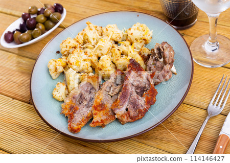 Fried fatty and juicy lamb and vegetable side dish of cauliflower with wine and olives 114146427