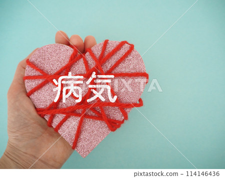 Heart wrapped in red yarn with the word "illness" written on it, copy space 114146436