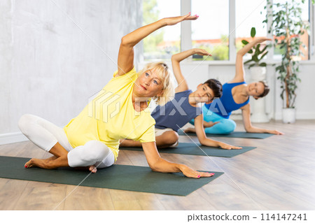 Family three generations do half lotus position Sidhasana with body tilt Family three generations do half lotus position Sidhasana with body tilt 114147241