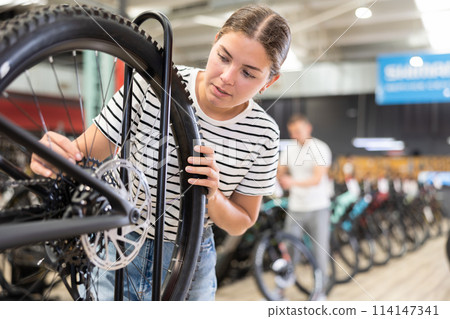 Young woman choosing bike in store 114147341