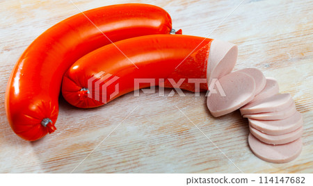Mortadela sausage cut in slices on a wooden surface 114147682