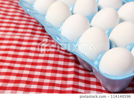 Carton of Eggs on Rustic Table With Checkered Table Cloth 114148596