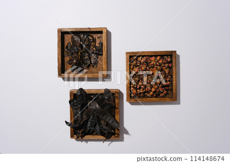 Top view photo with ingredients for producing black locust fruit cosmetic, all ingredients contained in rectangle wooden tray against on white background. Space for text 114148674