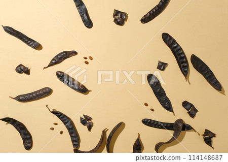 Plenty black locust fruits and seeds scattered flat lay on light brown table, photo was taken with a top-down camera angle. Blank space for displaying or presentation Plenty black locust fruits and seeds scattered flat lay on light brown table, photo was taken with a top-down camera angle. Blank space for displaying or presentation 114148687