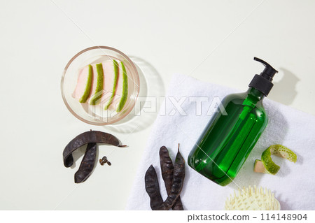 Green bottle without label, black locust pods and grapefruit peel isolated on white background from above view. Copy space for text Green bottle without label, black locust pods and grapefruit peel isolated on white background from above view. Copy space for text 114148904