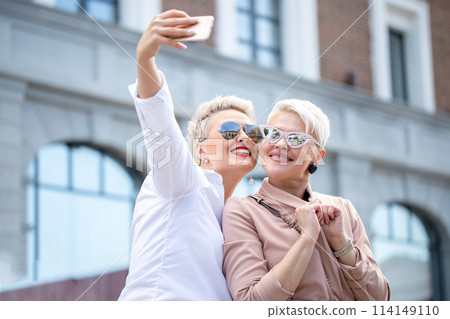 stylish adult business women pose for selfie outside near office building 114149110