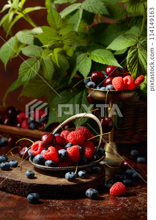 Berries with leaves on an old brown table. Berries with leaves on an old brown table. 114149163