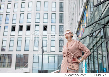 mature female is walking in jacket on street outdoor 114149174