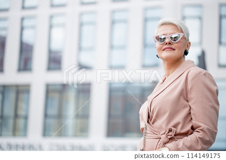 mature female is walking in jacket on street outdoor mature female is walking in jacket on street outdoor 114149175