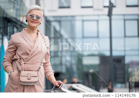 mature female is walking in jacket on street outdoor mature female is walking in jacket on street outdoor 114149176