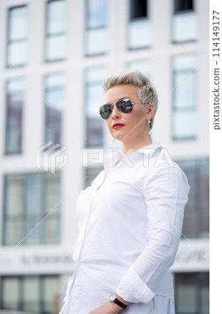 mature female is walking in jacket on street outdoor mature female is walking in jacket on street outdoor 114149177
