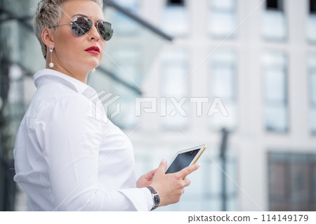 adult Business woman with tablet pc with office district on background 114149179