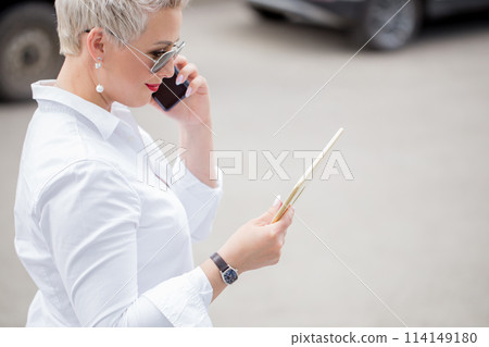 adult Business woman with tablet pc with office district on background adult Business woman with tablet pc with office district on background 114149180
