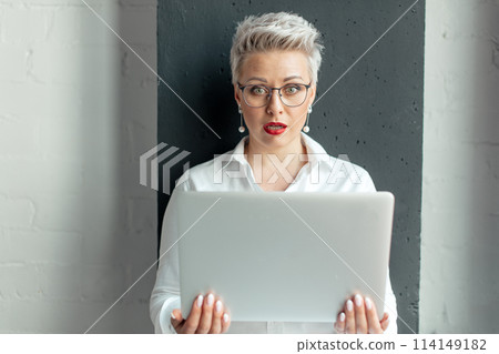 Surprised woman reading unexpected information in laptop with open mouth and bulging eyes Surprised woman reading unexpected information in laptop with open mouth and bulging eyes 114149182