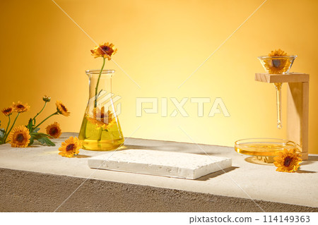 On gray concrete podium, empty brick podium decorated with fresh calendula flowers and lab glassware on yellow backlit background. Space for design, advertising photo On gray concrete podium, empty brick podium decorated with fresh calendula flowers and lab glassware on yellow backlit background. Space for design, advertising photo 114149363